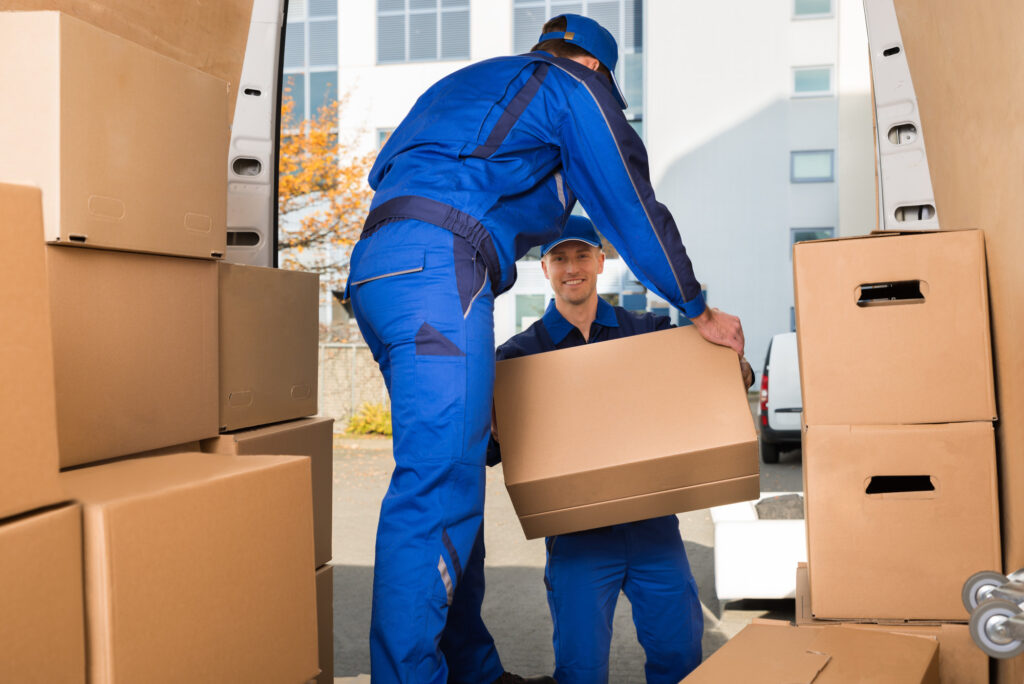 professional movers moving packed boxes off of their moving truck